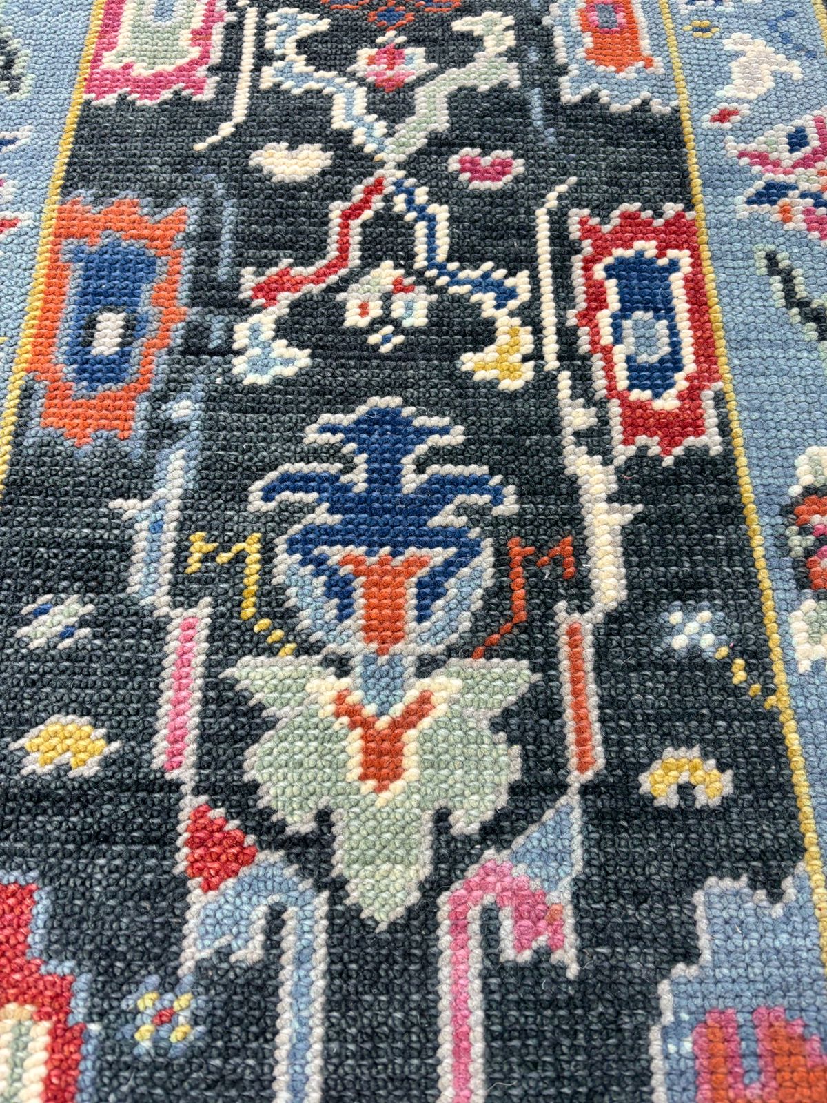 Low-angle view of hand-knotted Oushak runner rug emphasizing texture, weave, and wool quality