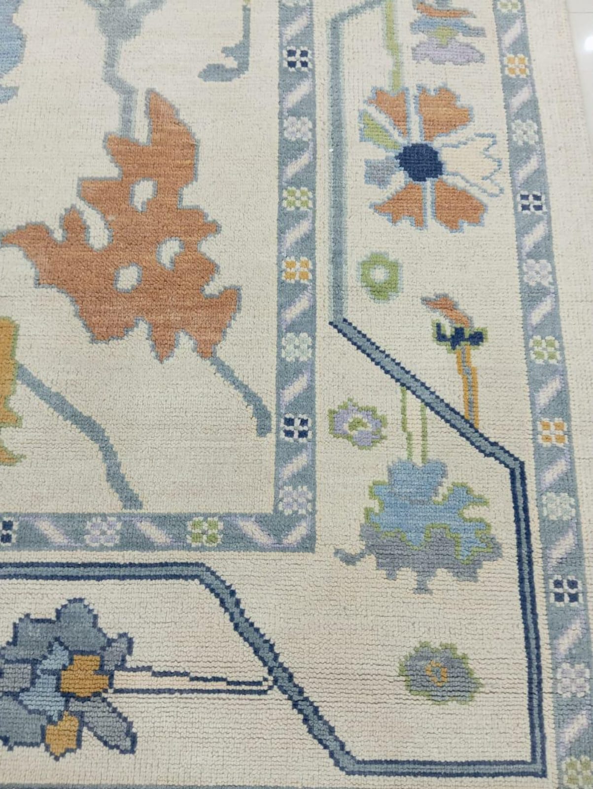 Close-up of a patterned rug with floral designs and geometric shapes.