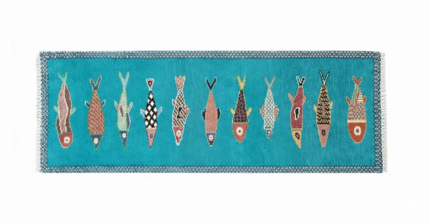 Horizontal view of artisan handmade fish runner rug with turquoise base and colorful coastal fish designs