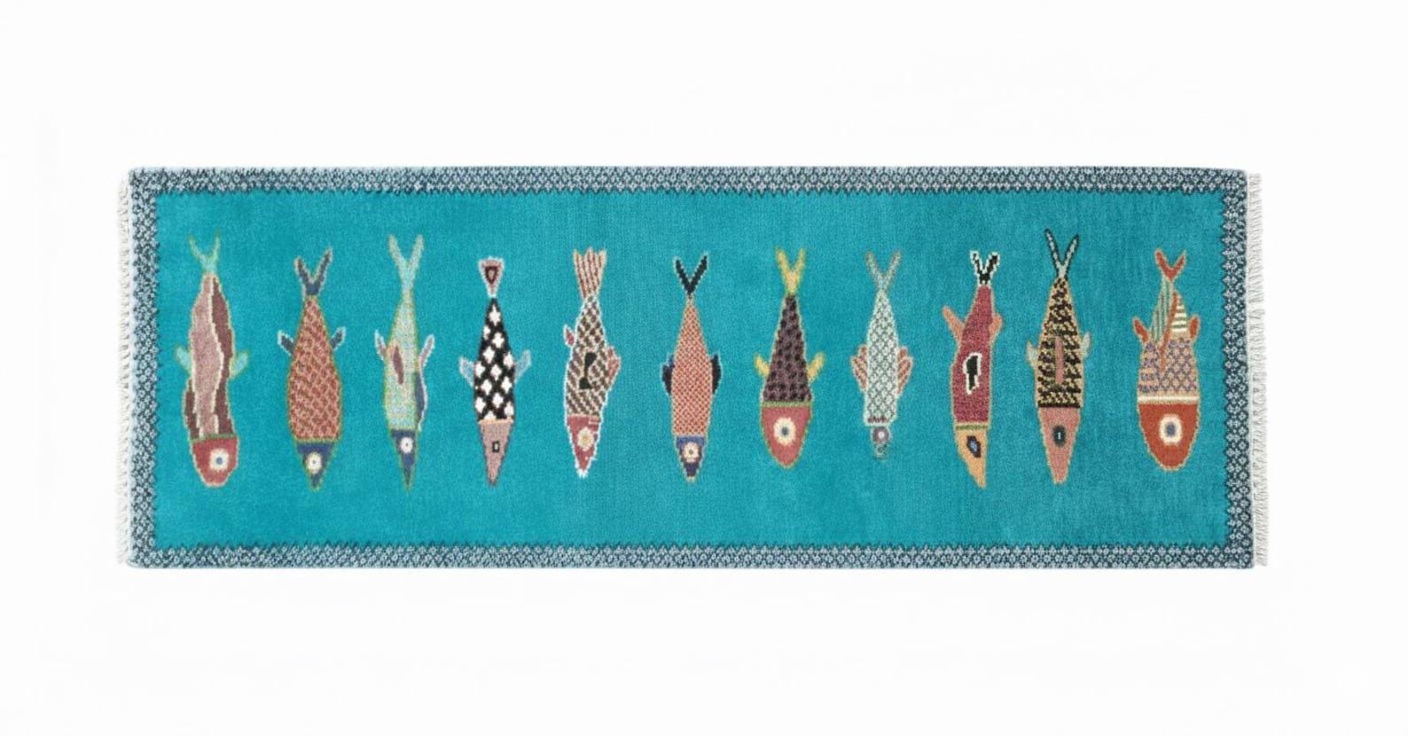 Horizontal view of artisan handmade fish runner rug with turquoise base and colorful coastal fish designs