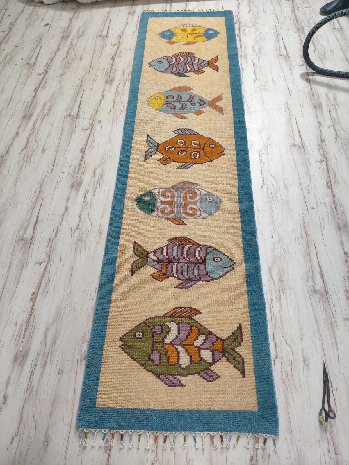 Detailed texture view of Oushakaura artisan fish runner rug for beach house and coastal interiors