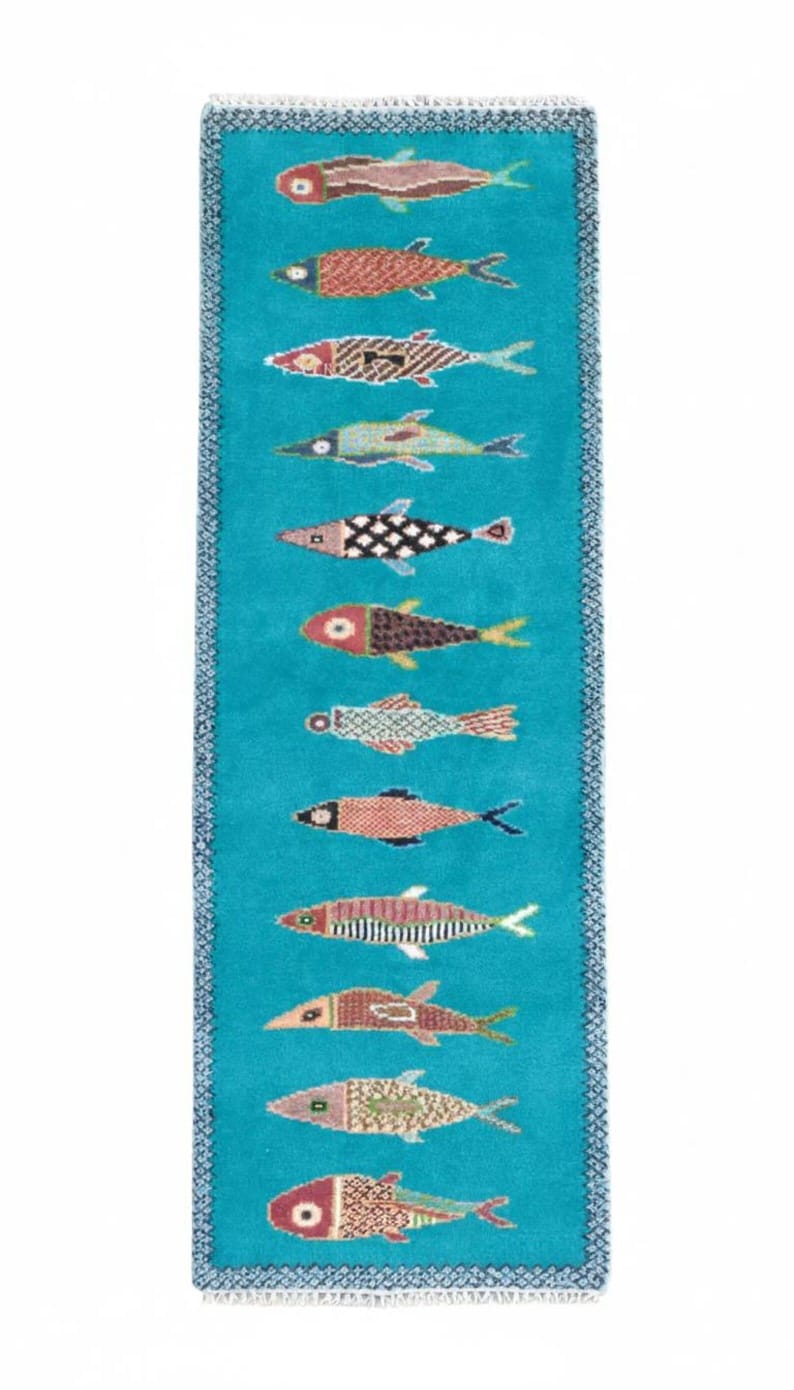 Top view of handmade nautical fish runner rug with turquoise background and decorative woven fish motifs