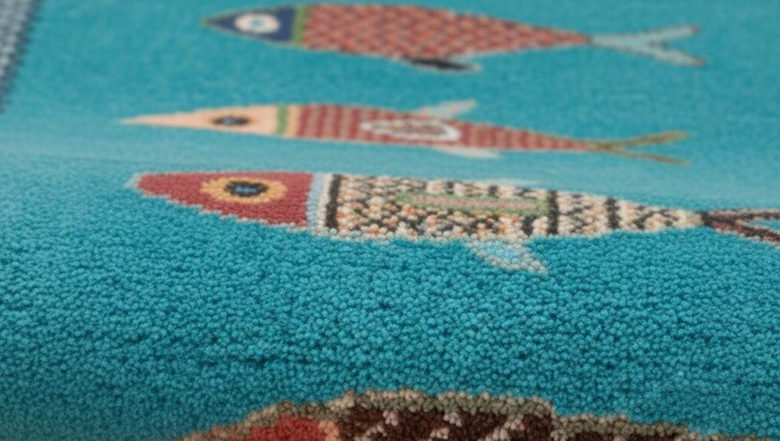 Detailed woven texture of handmade coastal fish rug by Oushakaura featuring artisan craftsmanship and turquoise tones