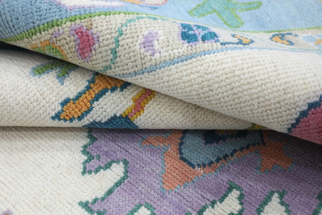 Folded corner detail showing wool pile texture of pastel blue hand tufted rug