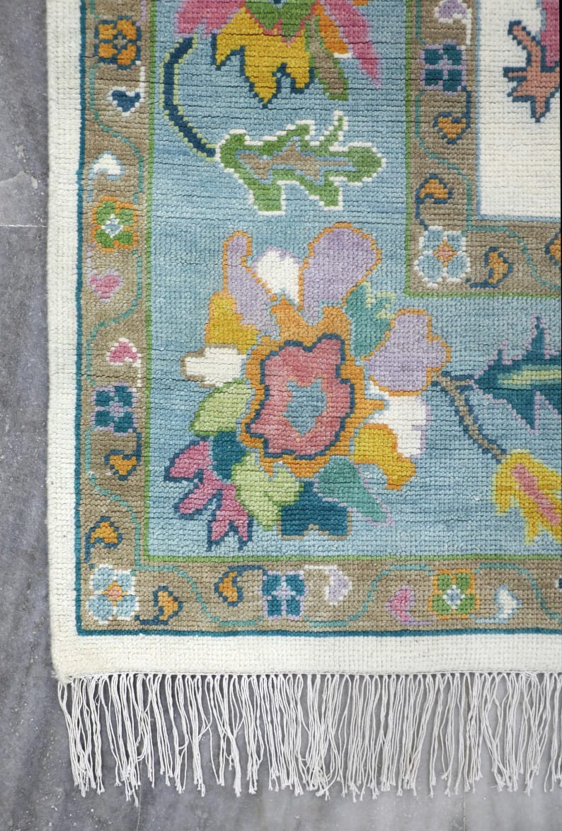 Fringe edge detail of pastel blue Oushak style hand tufted rug