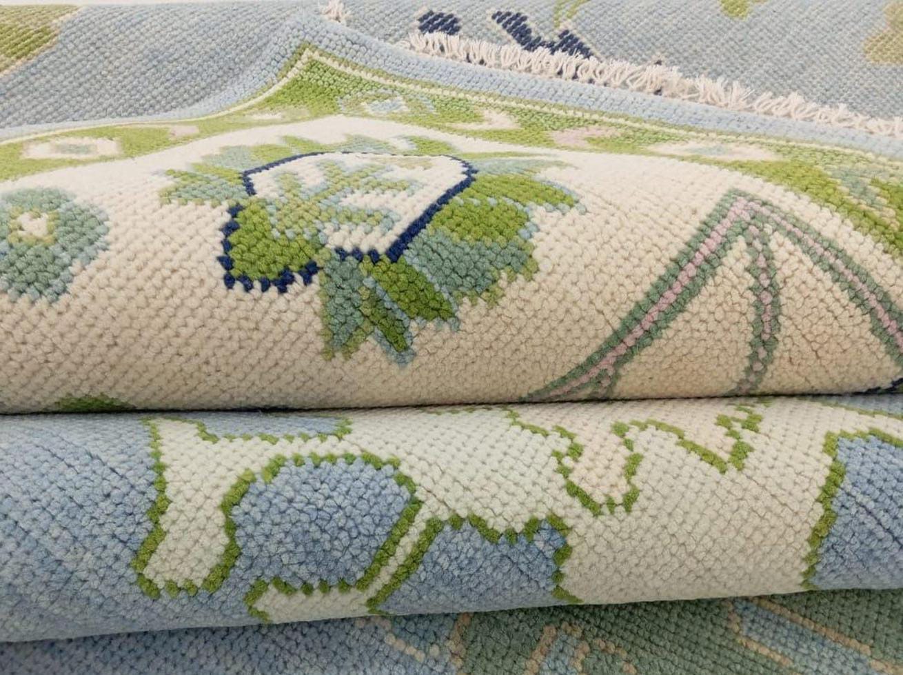 Close-up of handwoven Oushak wool rug showing pastel blue and olive green texture