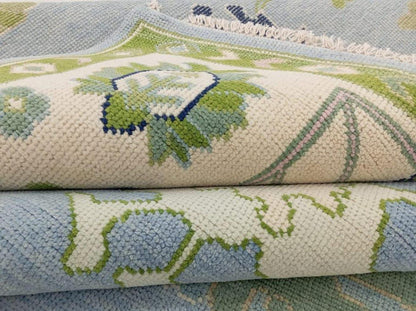 Close-up of handwoven Oushak wool rug showing pastel blue and olive green texture