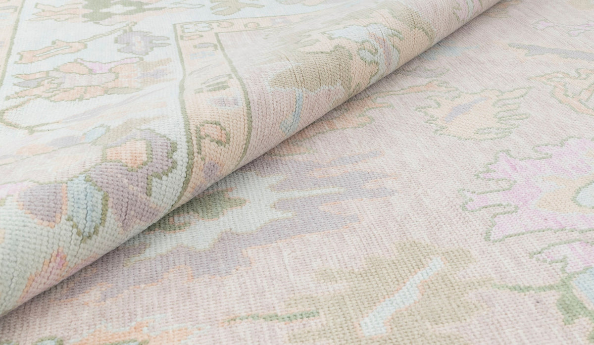 Pastel floral runner rug with soft pink blue and green botanical pattern shown folded