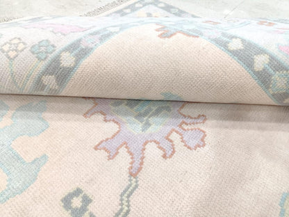 Close up of pastel floral medallion on ivory wool rug