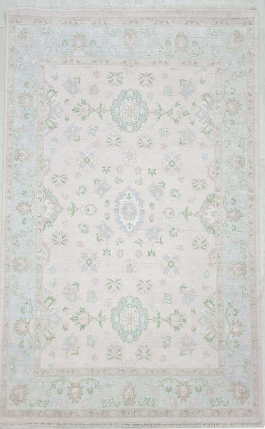 Pastel pink floral area rug with soft blue, sage green and ivory vintage-inspired pattern