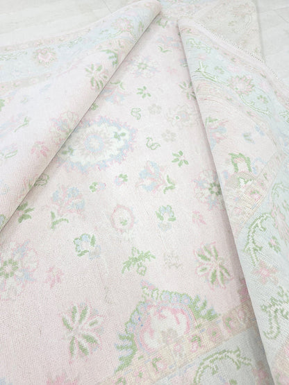 Pastel pink floral rug showing its woven texture and soft traditional botanical pattern
