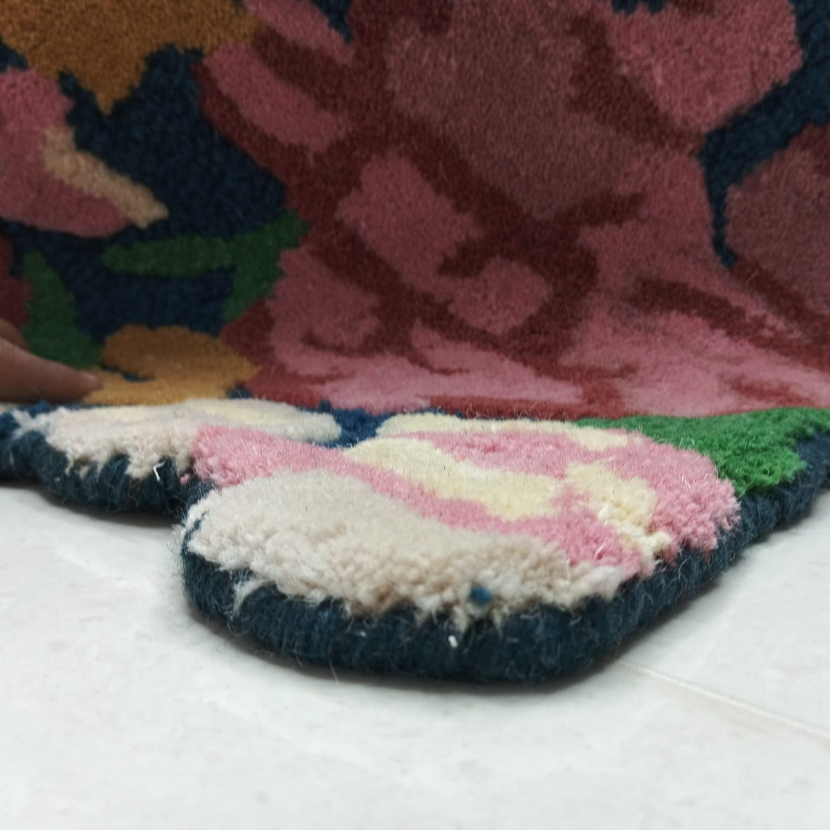 Close-up of raised pink and burgundy floral rug pile
