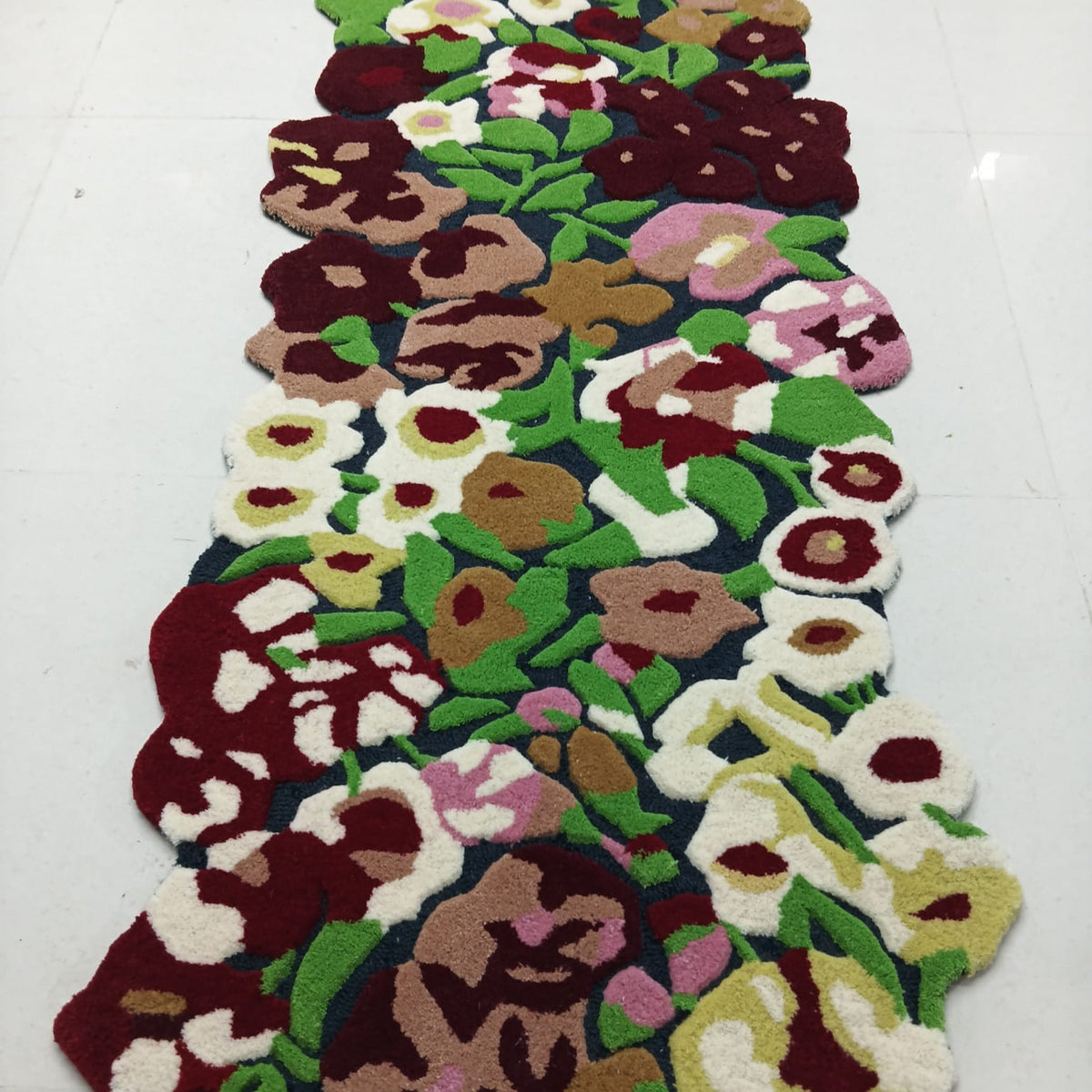 Close-up of raised pink and burgundy floral rug pile
