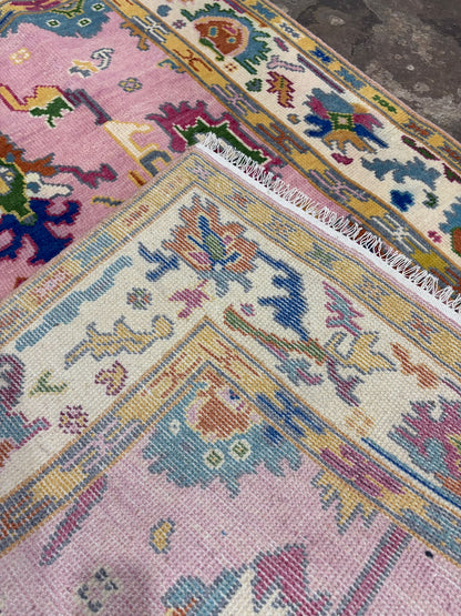 backside of a hand-knotted pink floral wool rug showing its construction