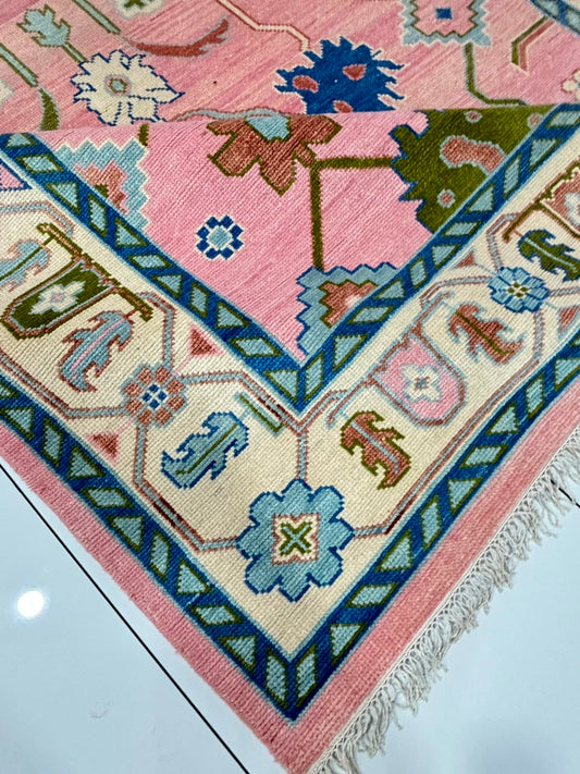 Corner detail of handmade blush pink vintage Turkish style rug.