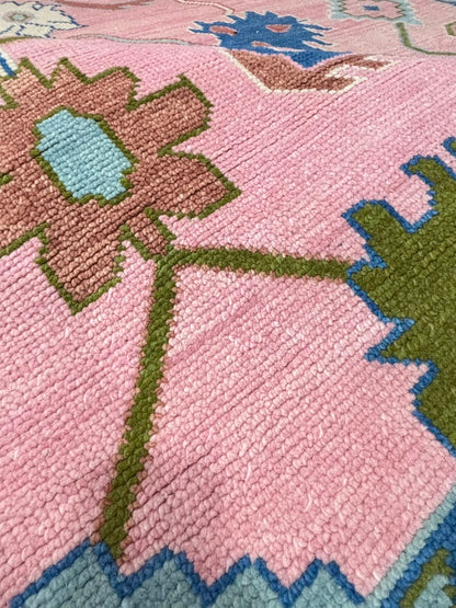 Close-up texture of a handmade blush pink wool Oushak area rug.