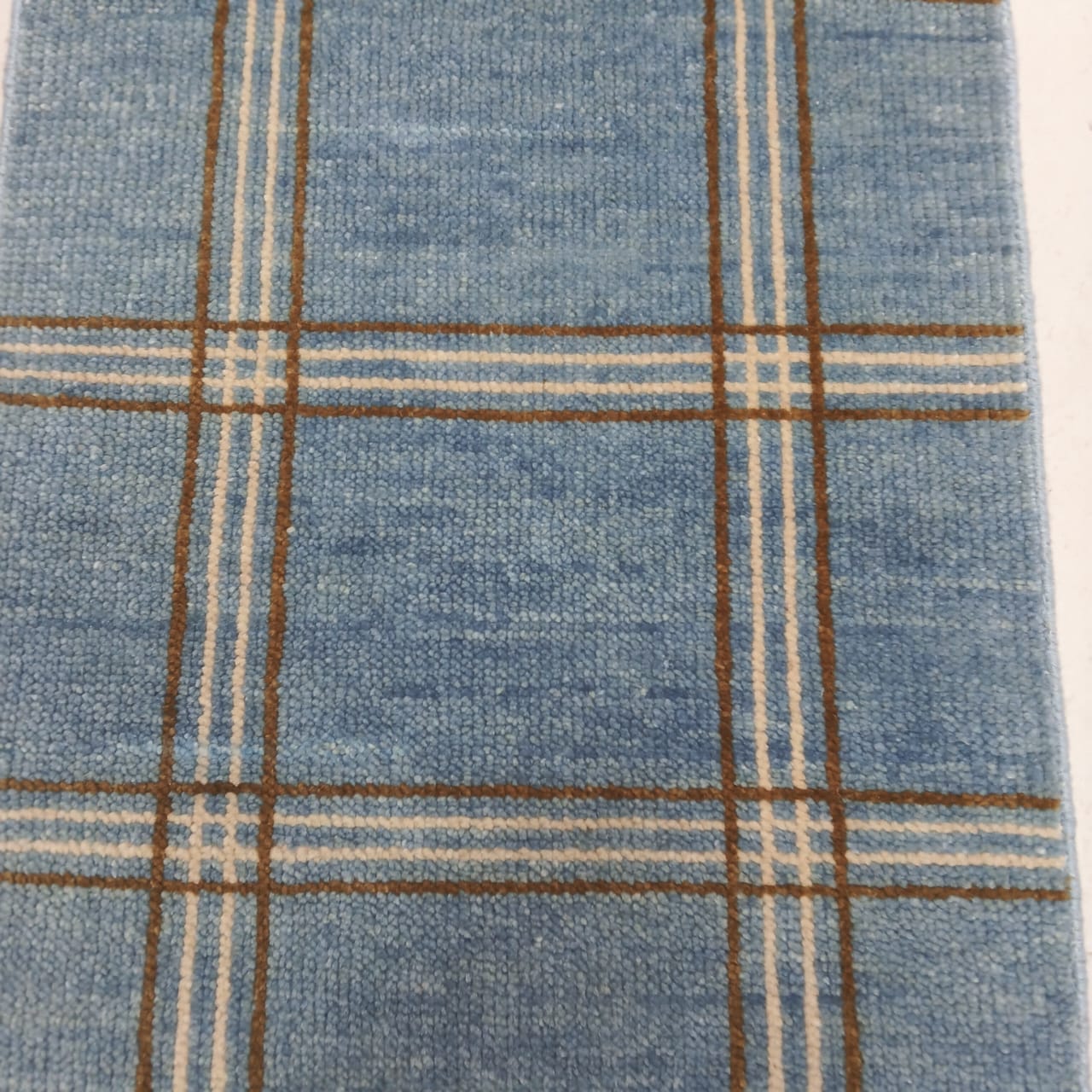 Detail of plaid pattern on modern blue wool area rug