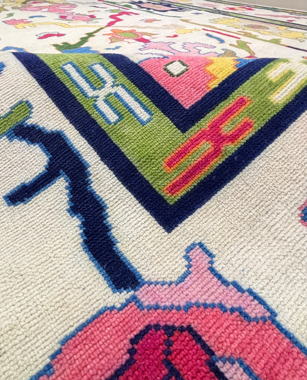 Close-up of the central geometric Scandinavian folk art motif on a handcrafted multicolor wool area rug.