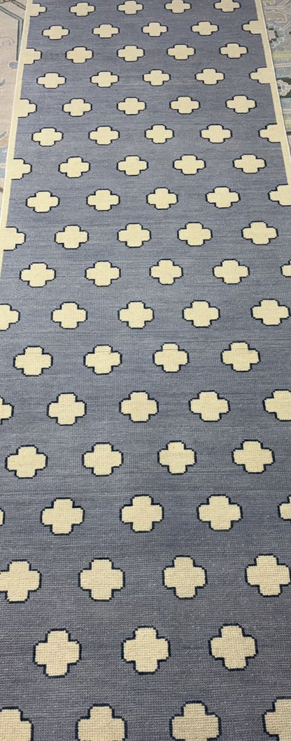 Full view of a handmade contemporary wool rug with an ivory geometric pattern on a dusty blue field.