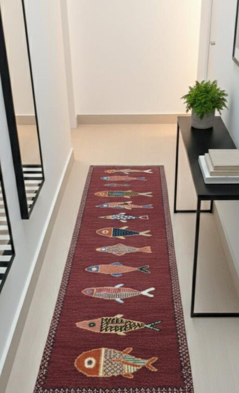 Red handmade fish runner rug styled in an entryway, adding coastal charm and artisan character.