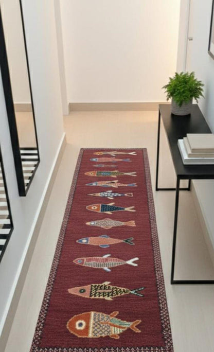 Red handmade fish runner rug styled in an entryway, adding coastal charm and artisan character.
