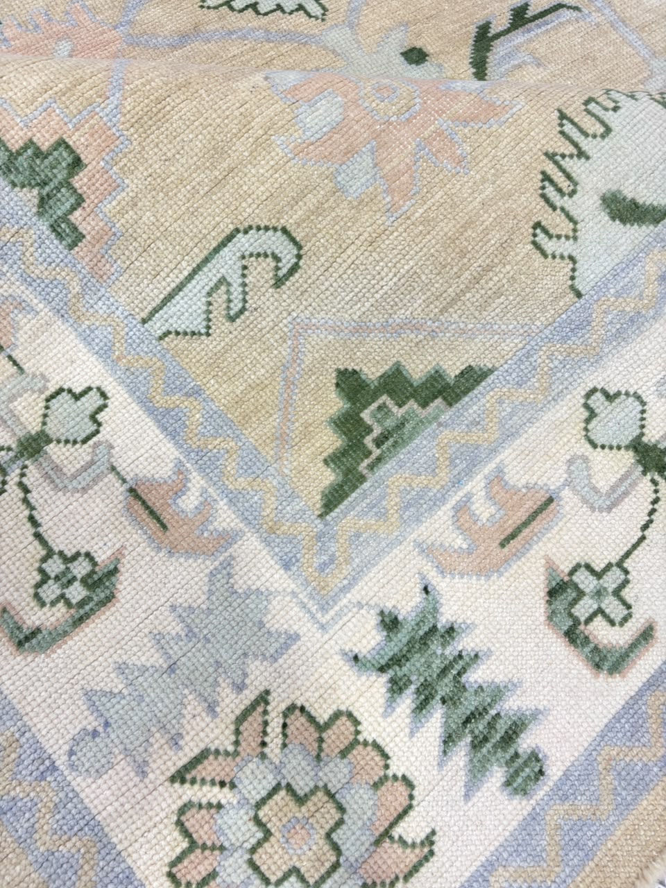 Sage green and beige Oushak-inspired rug with floral and geometric motifs