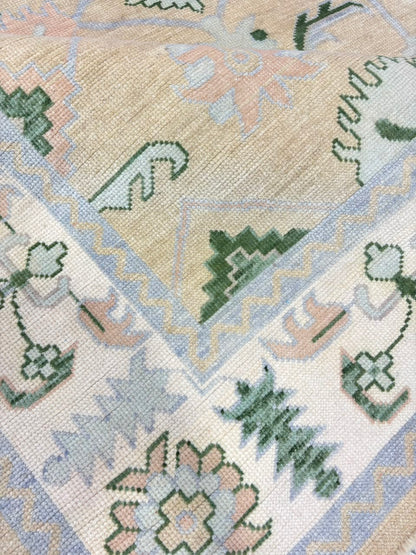 Sage green and beige Oushak-inspired rug with floral and geometric motifs