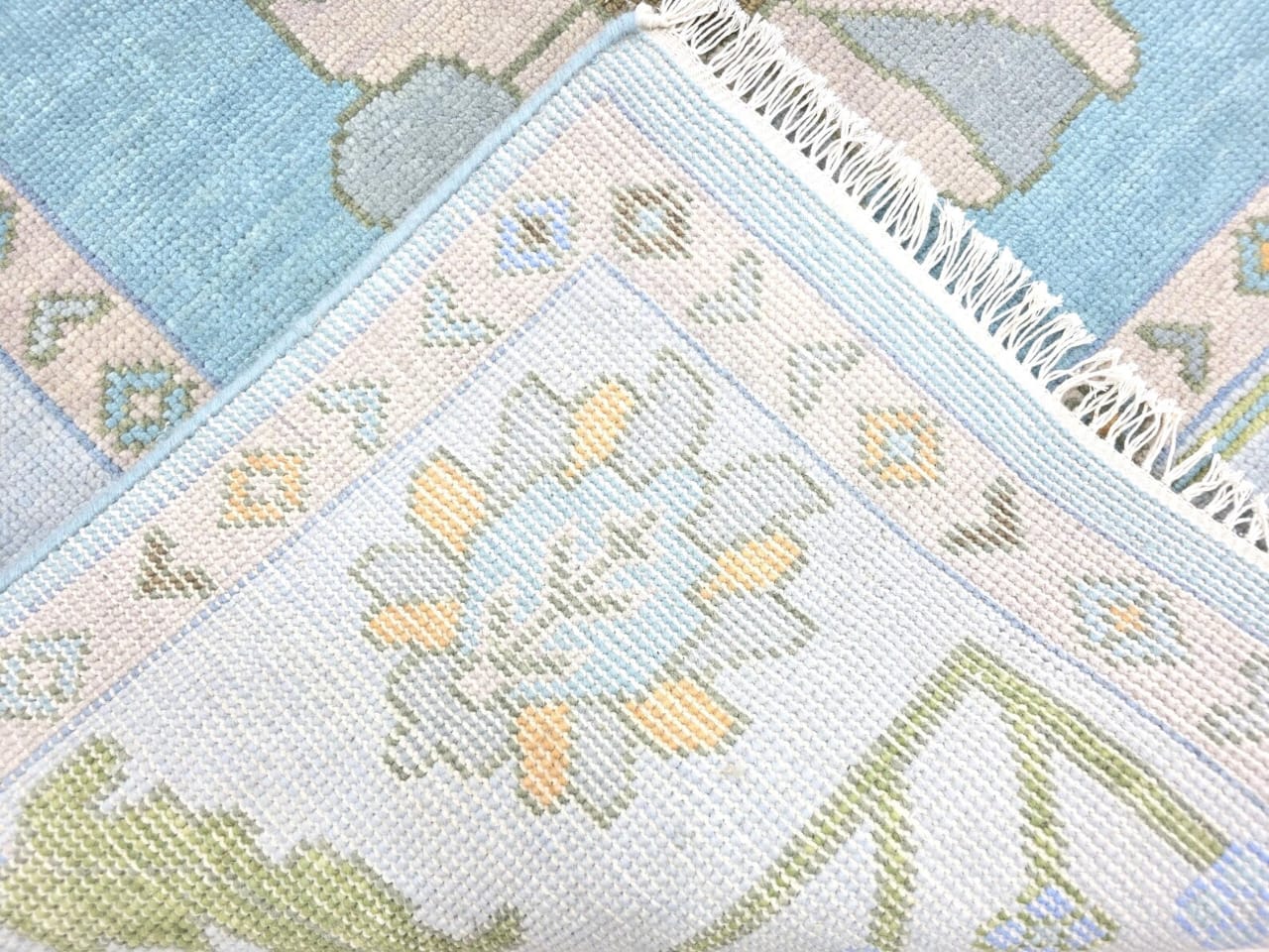 Close-up of a textured fabric with geometric patterns in pastel colors.