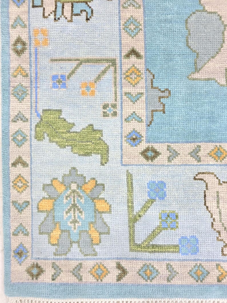 Close up of sky blue Oushak rug border with geometric and floral details