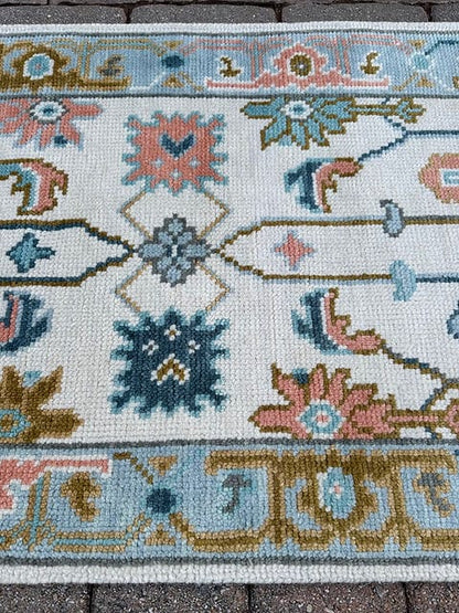 Detailed floral border of a handmade ivory and sky blue vintage runner rug.