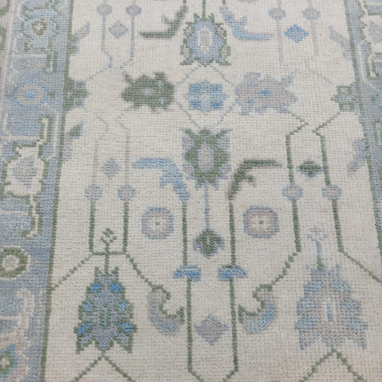 Traditional Turkish Oushak rug floral pattern in soft blue and ivory tones