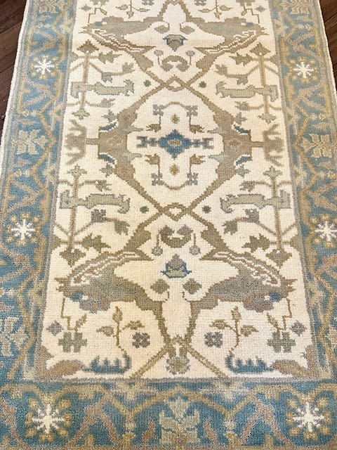 Traditional tribal rug featuring symmetrical animal motifs and artisan craftsmanship