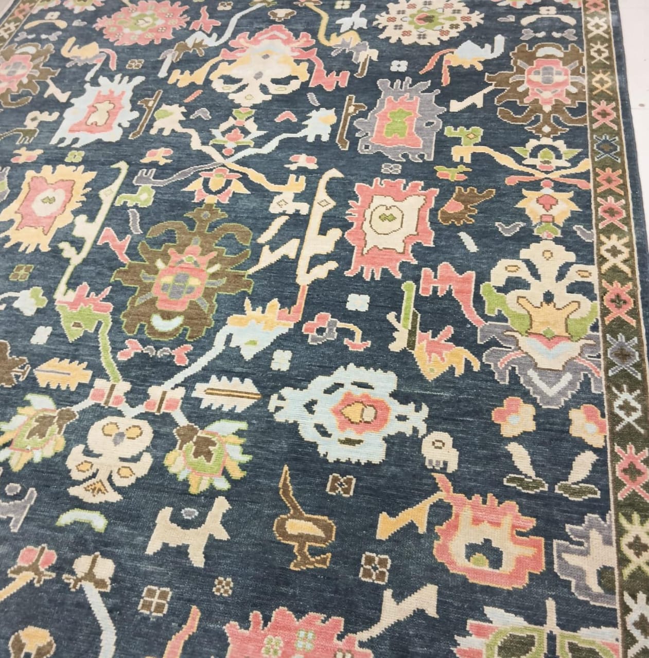 Tribal symbols woven into navy blue Oushak rug