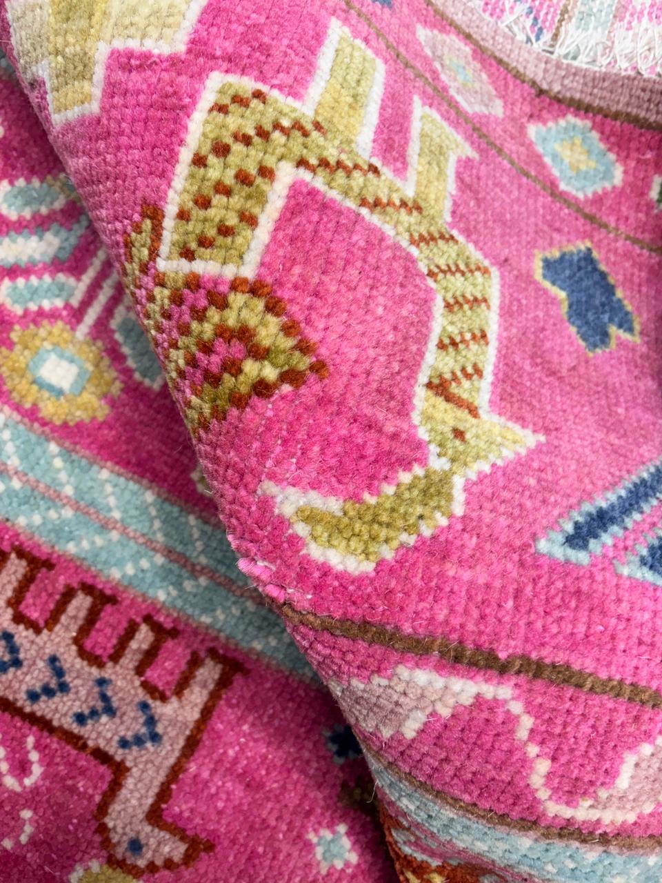 Close-up of tribal animal motif woven into pink Oushak rug