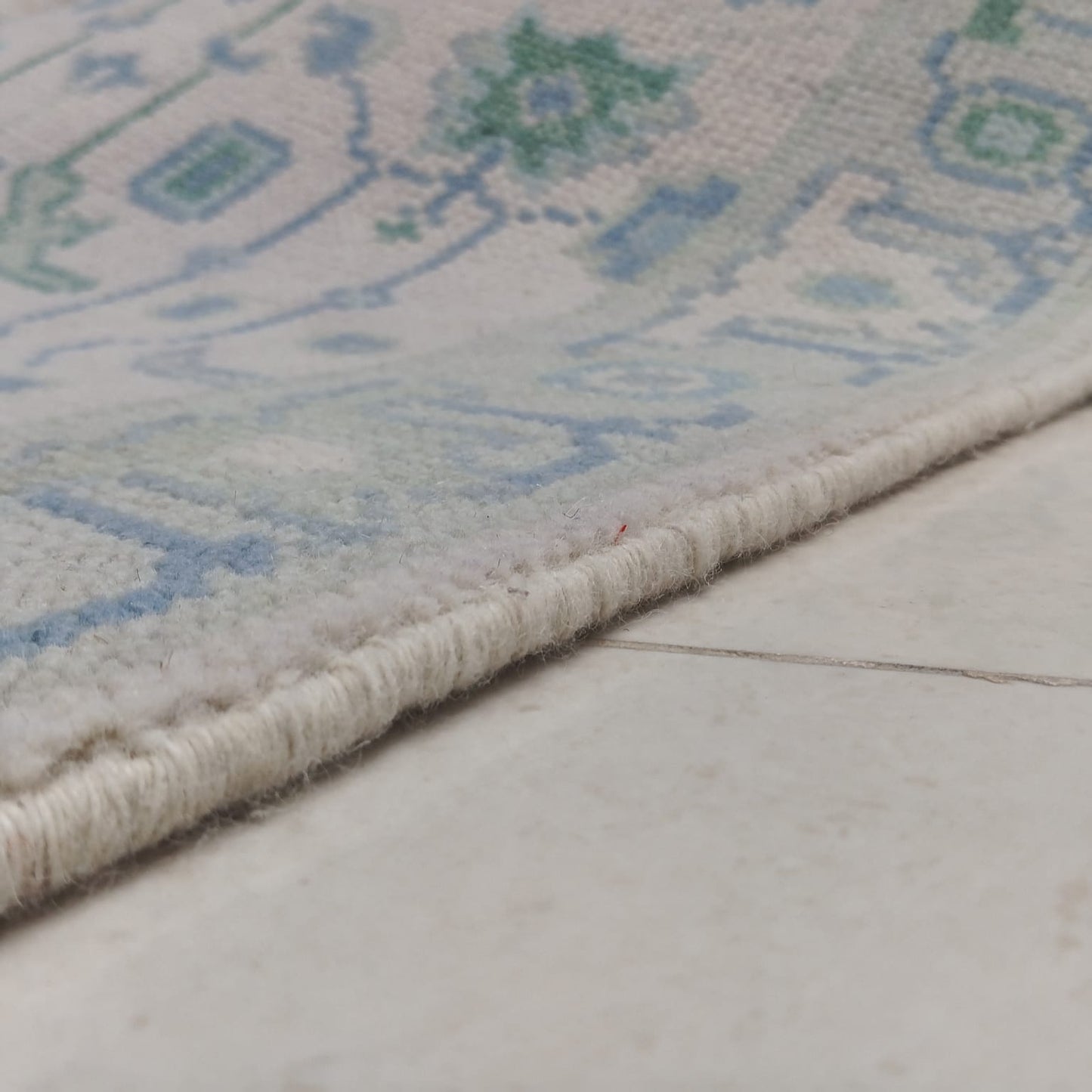 Tribal border detail of handwoven blue and green wool runner rug