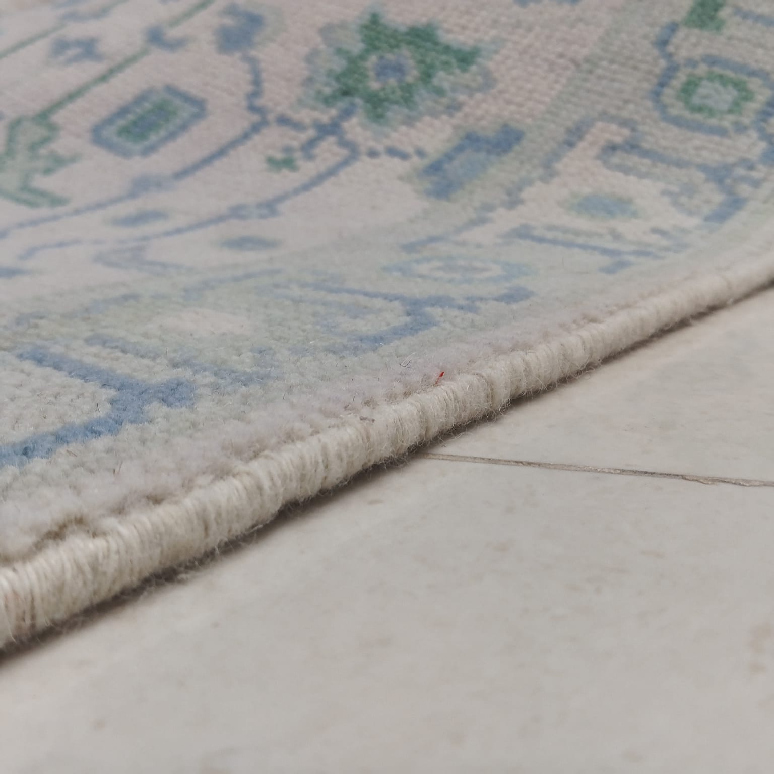 Tribal border detail of handwoven blue and green wool runner rug