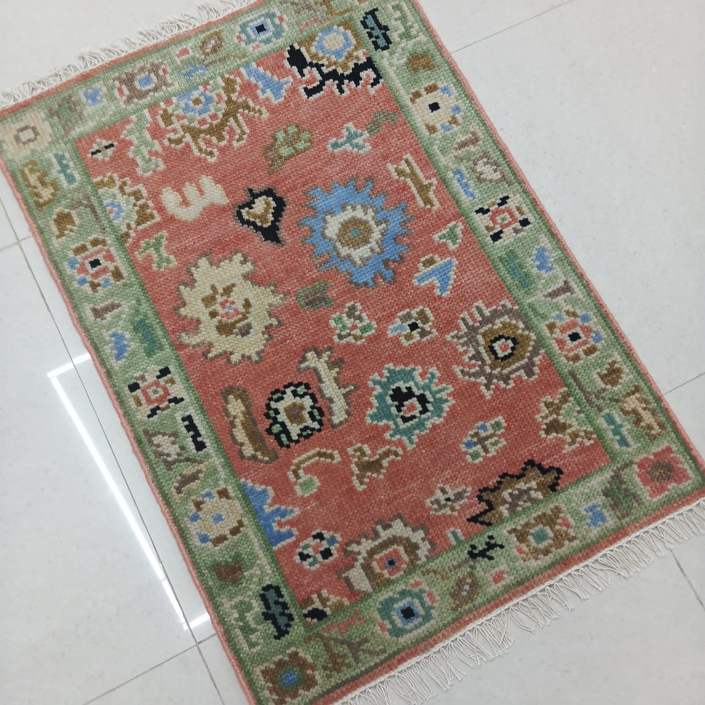 Traditional Oushak area rug handwoven from natural wool in salmon pink and sage green tones