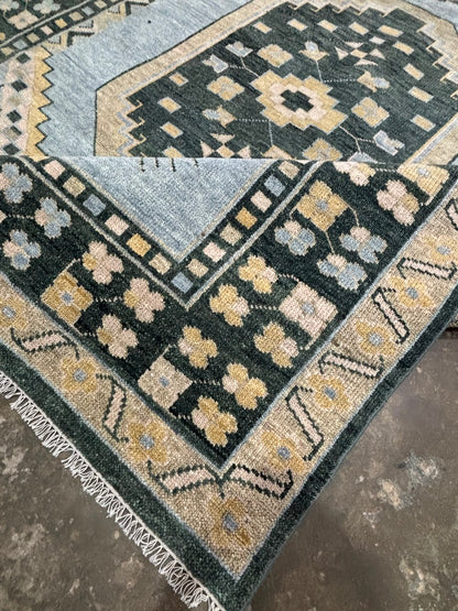 Folded handmade vintage blue Oushak wool rug displaying dense pile, soft texture, and handcrafted finish.